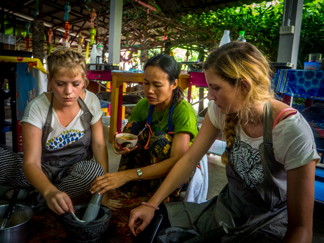 Guide Soon helps guests Andrea and Jasmine pound their curry pastes