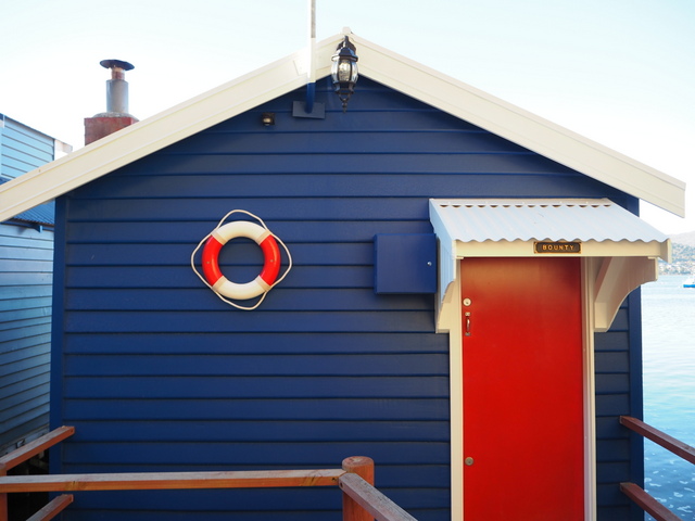 The boatsheds present a modest face to the land, concealing the comforts that await within many of them