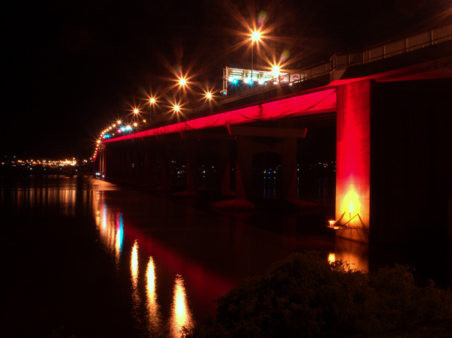 Tasman Bridge glowing red for Dark Mofo, viewed from the Western Shore of Hobart's Derwent River