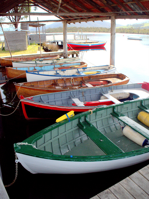 Colourful display of hand-built boats moored at the Wooden Boat Centre on the Huon River at Franklin