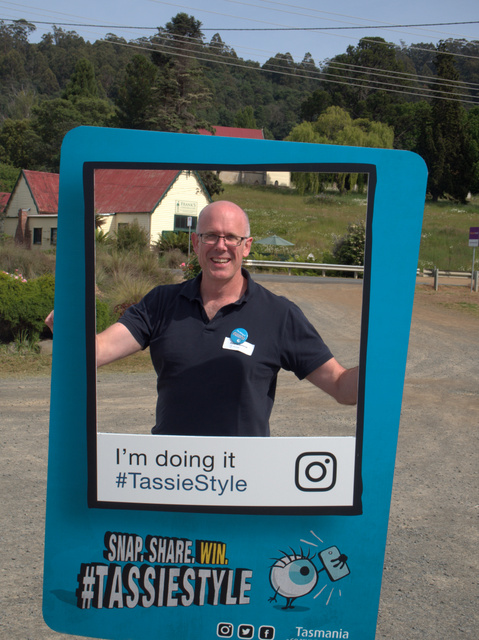 Tourism Tasmania's Pete Kilpatrick poses with a sign promoting their latest advocacy campaign, #tassiestyle
