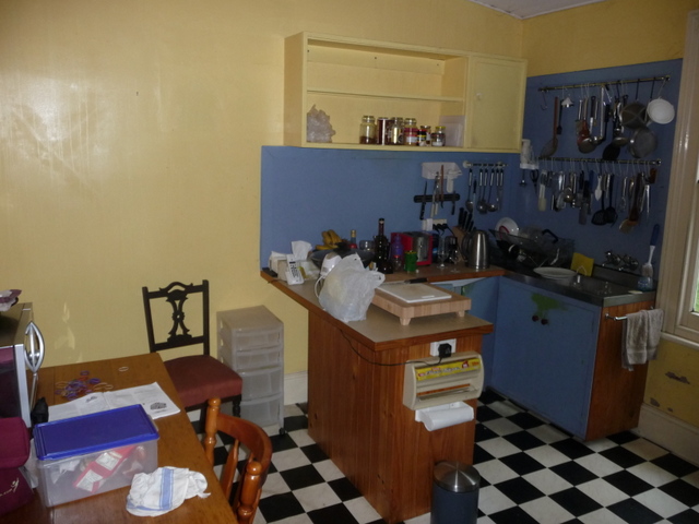 Bright paint and chequerboard lino brightened the dark kitchen